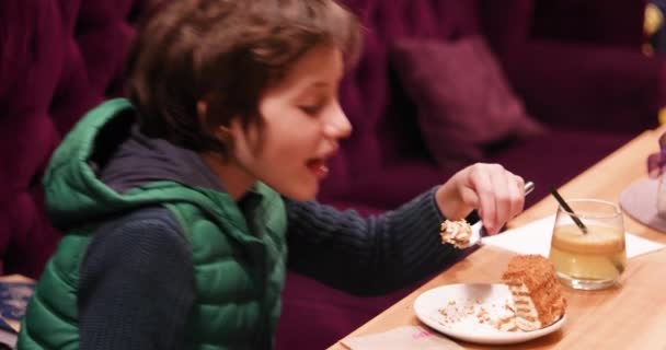 조끼를 귀여운 소년은 내부에 포크가 맛있는 케이크를 먹는다 — 비디오