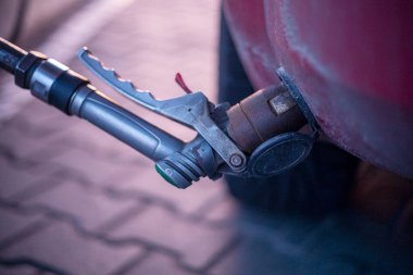 Benzin istasyonundaki benzin doldurma makinesinin vanasına pompayı yerleştir.