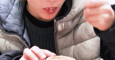 Yakın çekim çocuğu çay kaşığından dondurma yiyor, yatay olarak.