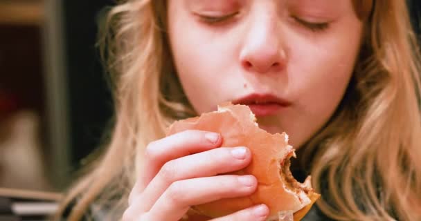 Gelukkig Meisje Met Lang Blond Haar Eet Een Hamburger Met — Stockvideo