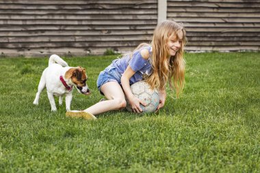 Uzun saçlı mutlu kızım Jack Russell Terrier 'dan topu aldı. aile hafta sonu