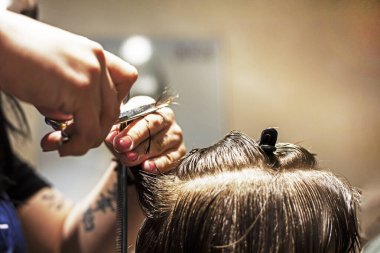 Berber dükkanı bıçak altında ıslak ve temiz saçların uçlarını kesiyor.