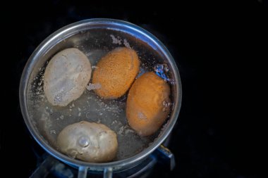 Sobanın üstünde bir tencerede yumurta haşla. Yumurta pişirme sağlıklı yeme konsepti, yassı