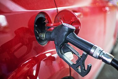 Benzin istasyonundaki kırmızı arabaya benzin doldurun. Petrol ürünleri krizi. Enerji ekolojisi