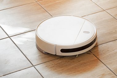 Robot elektrikli süpürge oturma odasındaki döşemeleri temizler ve yıkar.