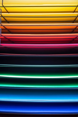 Raflara serilmiş çok renkli tasarım kağıdının soyut arkaplanı. dikey