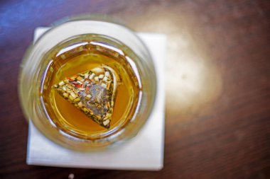 Şeffaf bardakta bir poşette meyve suyu çayı. Düz çizgi