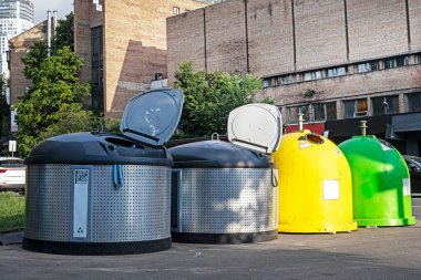 Güneşli bir günde sokakta çöp tenekelerini ayırmak. Çevre için ekoloji ve bakım