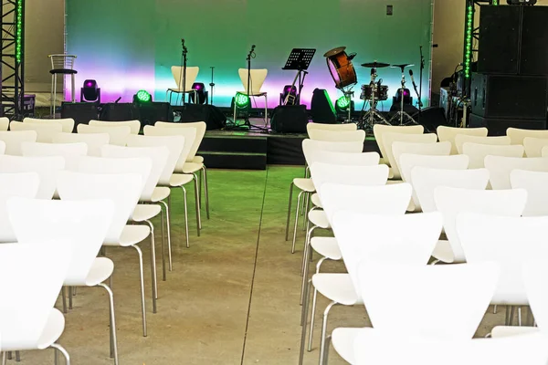 concert music stage before performance with white chairs. horizontal