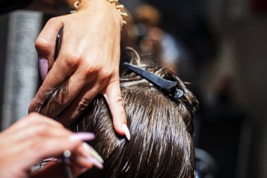 Koyu sarı saçlı bir çocuğun tarağının altında makasla kesilmiş. Moda saç kesimi