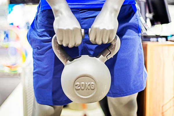 mannequin in sports shorts holds a kettlebell in his hands. Healthy lifestyle and sports