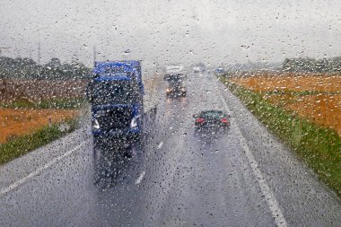 Kamyonlar yağmur sırasında ana kaygan yol boyunca sürerler. Kötü hava. Görüş mesafesi düşük