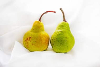 Hafif kumaş zemin üzerinde iki taze armut. sağlıklı beslenme