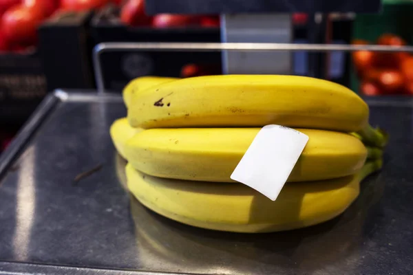 Süpermarkette bir avuç muzu tartmak.