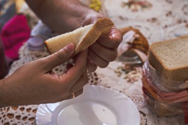 Kahvaltıdan önce elinde dilimlenmiş ekmek tutan bir adam.