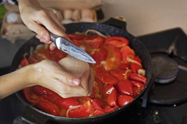 Bir yumurtayı domatesli tavaya kır.