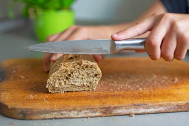 Mutfaktaki kesme tahtasına karabuğday ekmeği kes.