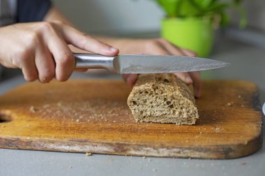 Mutfaktaki kesme tahtasına karabuğday ekmeği kes.