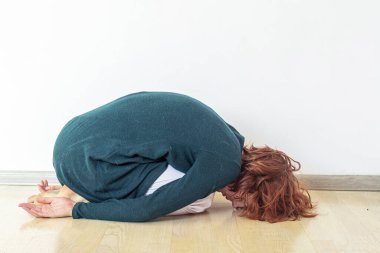 Genç kız odasında çocuk pozunda yatıyor.