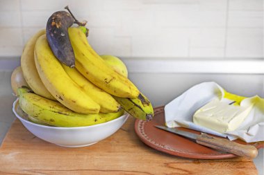 Mutfakta muz yağı ve elmalı bir demet muz.