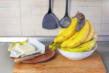 Mutfakta muz yağı ve elmalı bir demet muz.