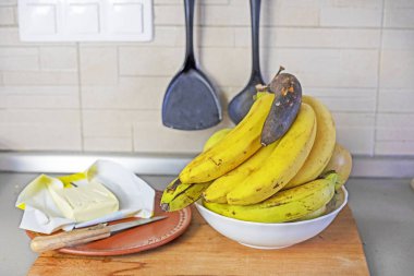 Mutfakta muz yağı ve elmalı bir demet muz.