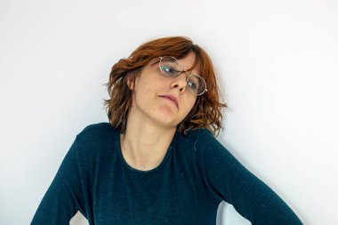 Açık arkaplanda gözlük takan kızıl saçlı güzel bir anime kızın portresi.