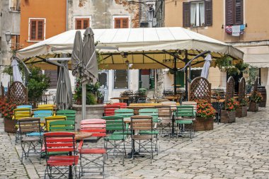 Hırvatistan 'da bulutlu bir günde ahşap sandalyeli boş bir kafe