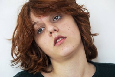 Düşünceli genç bir kızın yakın plan portresi. Kızıl saçlı, şık bir anime tarzı var.