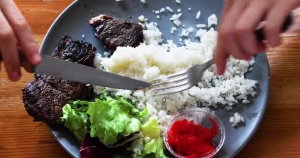 ナイフとフォークを使った焼肉とサラダで白米を食べる 上からの眺め — ストック動画