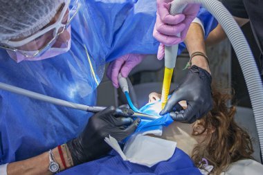 Bir hastanın diş tedavisi sırasında dişçi ve asistanı