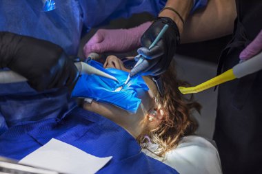 Eldivenli bir dişçi ve asistan bir gencin ağrıyan dişlerini tedavi eder. Diş bakımı ve sağlık