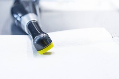 Diş tedavisi sırasında dolguları onarmak için diş fotopolimer lambası peçetelerin üzerinde yatar