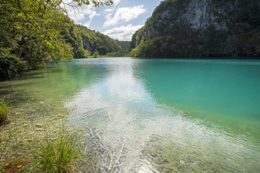 Güzel mavi Plitvice gölleri sonbaharda bulutlu bir günde. Avrupa 'yı dolaşmak