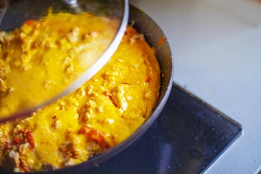 Açık bir kapağın altında domatesli ve tavuklu sıcak omlet pişir. sağlıklı atıştırma