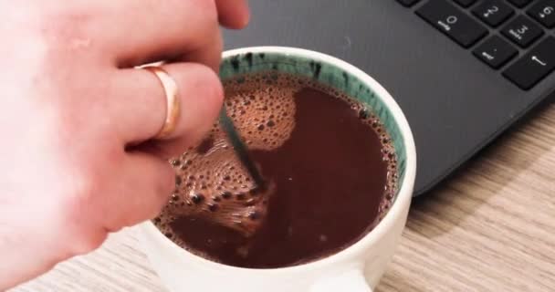 在电脑前用勺子搅拌成一杯热的天然巧克力 — 图库视频影像