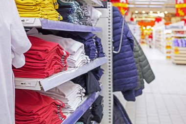 Süpermarkette çok renkli erkek tişörtleri ve paçavralar var. Moda & Biçimi