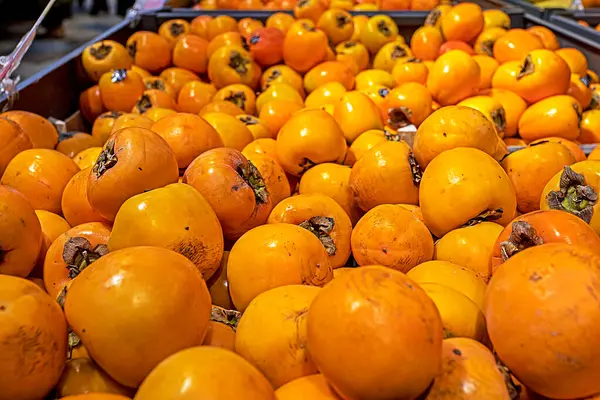 Süpermarketteki konteynırlarda olgun hurma ve Sharon. Bütçe tasarrufu