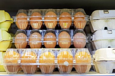 Dükkandaki plastik kaplarda çiftlik tavuğu yumurtalarının yakın plan çekimi.