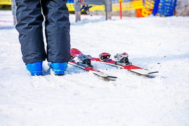 Kayakçı sabahleyin kayak asansörünün girişinin yanında duruyor. Aktif aile tatili