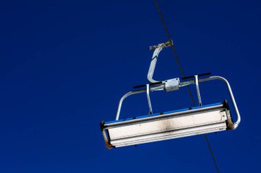 Mavi gökyüzünün arka planında bulutlu bir kayak asansörünün yakın çekimi. Kayak merkezi etkinlik eğlencesi