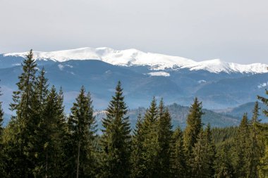 Güneşli bir günde bir kayak merkezinde karlı dağ zirveleri. Aileyle sağlık tatili