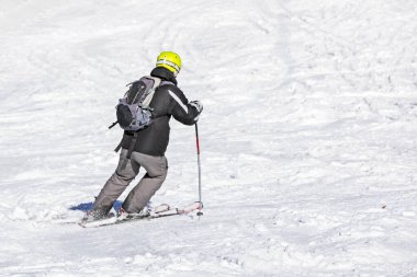 Kayakçı güneşli bir günde bir yokuştan iner. Aktif eğlence. Okul tatili