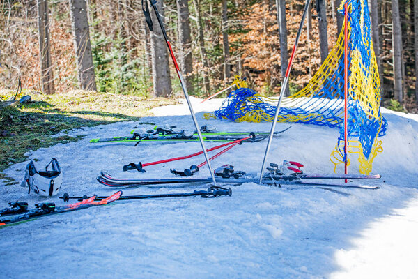 лыжные палки и лыжи на снежном склоне в солнечный день