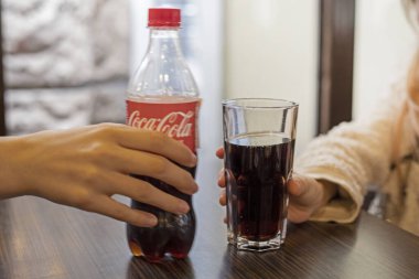 Ukrayna 'da İvano Frankovs' ta 31 Mart 2024 'te bir kafede bir bardak Coca-Cola içen kızlar