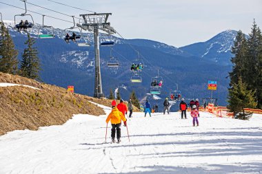 Kayakçılar orta seviye bir kayak yokuşundan inmeye başlarlar. Aktif eğlence. Sağlıklı yaşam tarzı