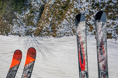 Kayak pistinin arka planında anne ve oğulun kayakları var. Aktif okul tatili