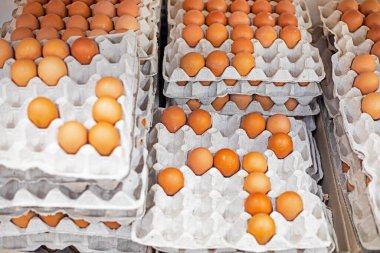 Marketteki tezgahın üzerindeki karton kaplarda kahverengi tavuk yumurtaları. ekonomik kriz