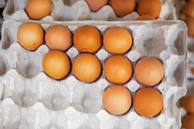 Marketteki tezgahın üzerindeki karton kaplarda kahverengi tavuk yumurtaları. ekonomik kriz