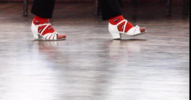 Beyaz dans ayakkabılı kız yerde dans alıştırması yapıyor..